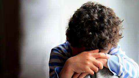 Getty Images A child with his head in his hands