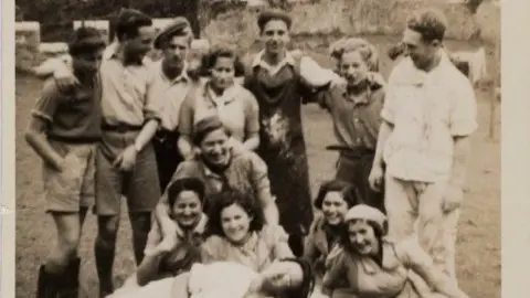 Gwyrch Castle Trust Archive Black and white picture of kids in the garden. They smile with their arms aorund each other