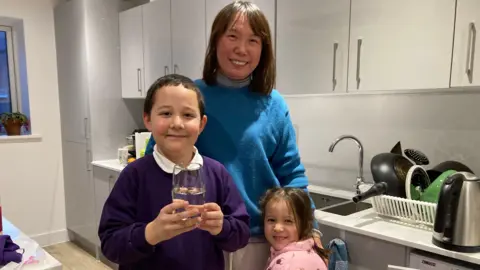 Jozef Hall/BBC Jin Zhang and her two children, a boy and a girl