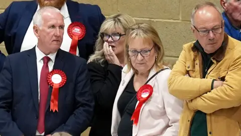 Labour party activists look on as ballot papers are counted for the 2026 Essex County Council election at Clacton Leisure Centre in Essex