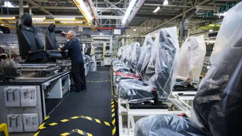 Getty Images An employee fits a part to a seat for an Aston Martin automobile at the Aston Martin Lagonda Ltd. manufacturing and assembly plant in Gaydon, 