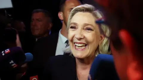 REUTERS/Yves Herman Marine Le Pen, French far-right leader and candidate for the far-right Rassemblement National (Rally National - RN) party, speaks to reporters after partial results in the first round of early French parliamentary elections in Henin-Beaumont, France, June 30, 2024.