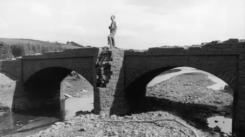 Getty Images A black and white photograph of old stone bridge which emerged from Llwyn-on Reservoir in 1976.