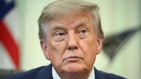 US President Donald Trump looks on before signing an executive order calling for more research and flexibility on vaccines, in the Oval Office of the White House in Washington, DC, on August 10, 2026. 