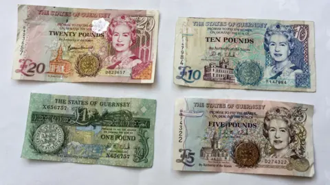 BBC Four Guernsey bank notes lined up on a table.