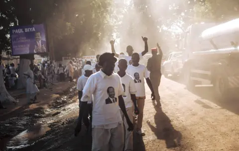 AFP In this photograph taken on September 29, 2018, supporters of the President Paul Biya walk in a street of Maroua, Far North region of Cameroon, after sn electoral meeting he held in the city.