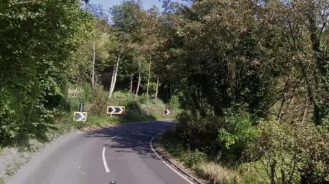 A tight corner of the B4058, surrounded by grass and trees