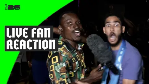 Cape Verde fan cheers while being interviewed by reporter Paul Ngie