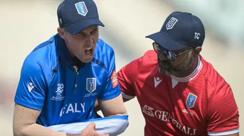 Wayne Madsen is helped from the field by a member of the Italy medical team after he dislocated his shoulder against Scotland