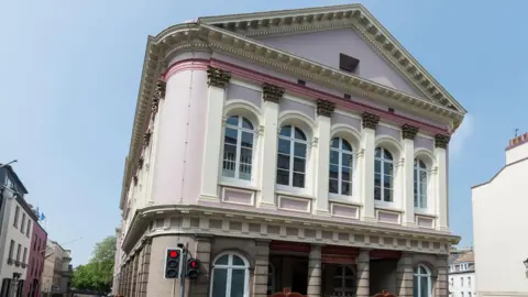 BBC The States of Jersey (Chambre Des Etats) in St Helier in Jersey in the Channel Islands. The building is mostly pink and white.