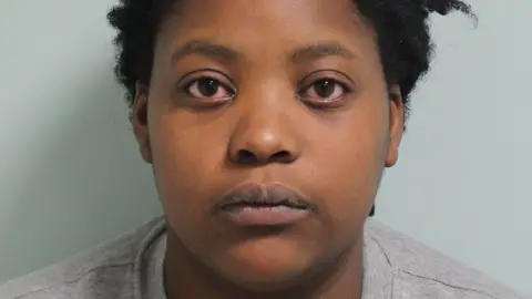 Metropolitan Police Police mugshot of Deveca Rose. She is staring at the camera and is wearing a grey sweatshirt