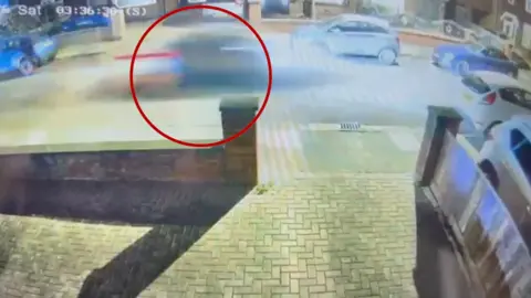 Video footage screenshot with a red circle around a speeding car.