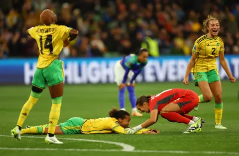 HANNAH MCKAY/REUTERS Jamaica's Solai Washington and Rebecca Spencer celebrate after the match as Jamaica qualify for the knockout stages of the World Cup