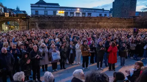 PA Media A large crowd of people stand in Derry's Guildhall Square