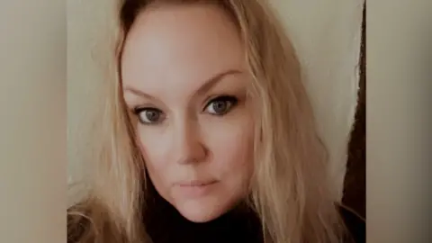 Jo Thompson Jo Thomspon is in the middle of the image. She has long blonde hair and is wearing a black jumper. 