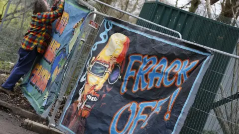 EDDIE MITCHELL A poster that reads "frack off"