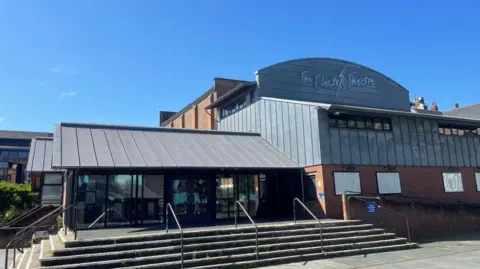 Guildford Borough Council A large building with steps. There is also a blue sky. 