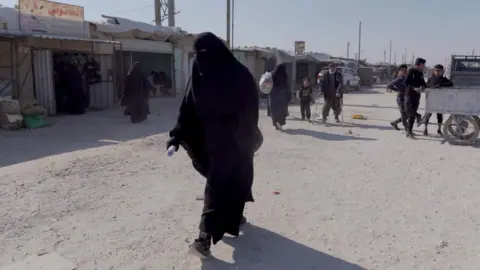 A woman walking in the al-Hol camp in north-eastern Syria