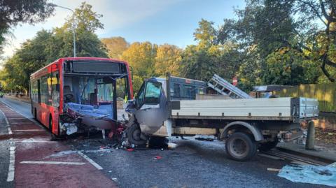 A collision between a bus and a flatbed truck