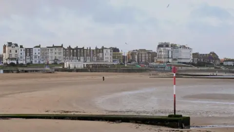 Getty Images A beach with a row of buildings near it. 