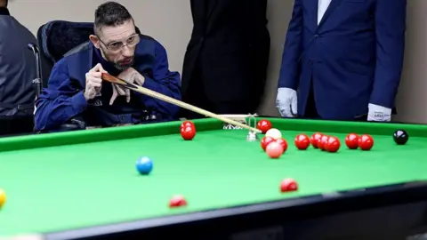 Matt is playing disability snooker - he is able to play it from his chair, using equipment to make the sport accessible.