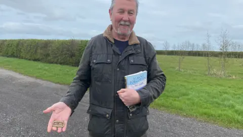 Chris Davies holding a rusty buckle