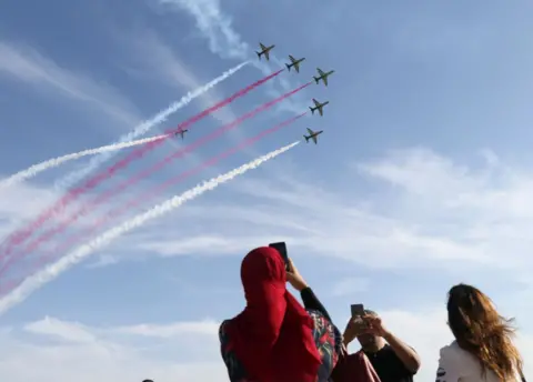 Getty Images People watch as planes fly overhead.