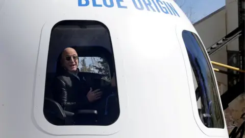 Getty Images Bezos speaks in 2017 from on board a spaceship built by his company Blue Origin