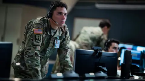 Netflix Anthony Ramos in A House of Dynamite, wearing camouflage standing in front of a computer screen