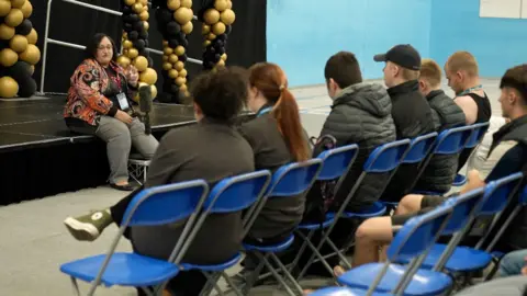 Students sat in a sports hall