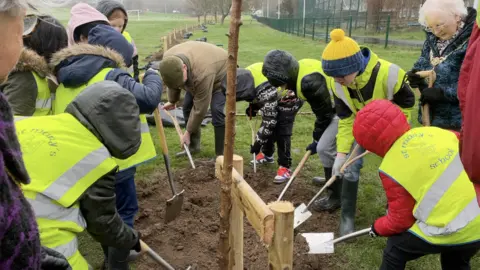 BBC Schoolchildren alongside the lieutenant governor planting the first tree