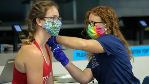 A nurse gives a vaccine at Tottenham Hotspur's stadium