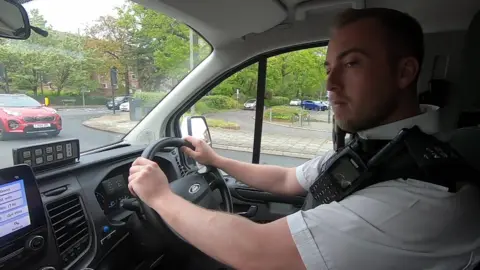 BBC PC Jack King driving in a police vehicle