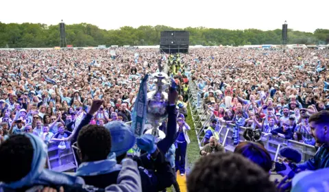 Coventry City Council A sea of fans dressed in sky blue can be seen from the stage as the team holds the Championship cup 