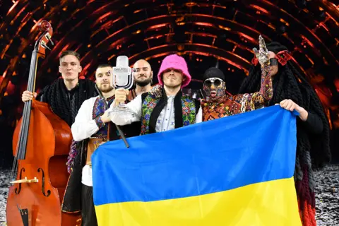 Giorgio Perottino / Getty Images Kalush Orchestra of Ukraine hold a Ukrainian flag on stage as they are named the winners of the 66th Eurovision Song Contest at Pala Alpitour in Turin, Italy