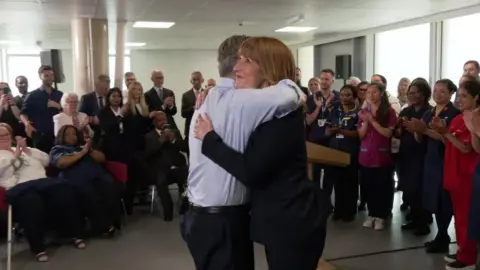 BBC Keir Starmer hugs Rachel Reeves, as NHS staff look on and applaud