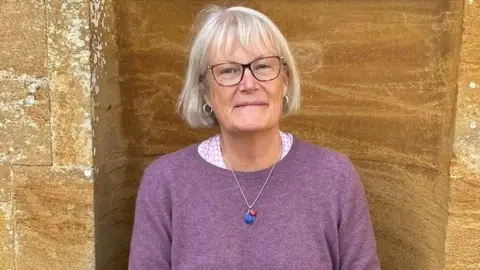Joan Edgington Joan Edgington in front of a stone wall