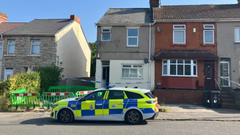A police car parked outside a semi-detached home.