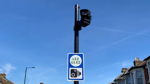 A camera and a sign for the ultra low emission zone on a London street