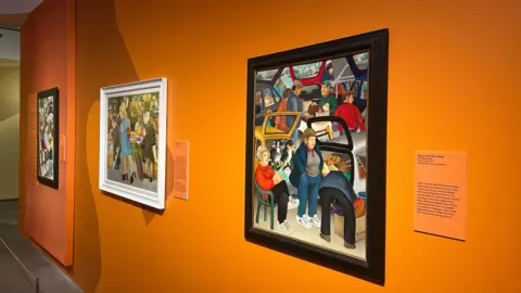 Three pieces of artwork by Plymouth artist Beryl Cook displayed on a bright orange wall. They are all individually framed with little orange signs explaining each painting.