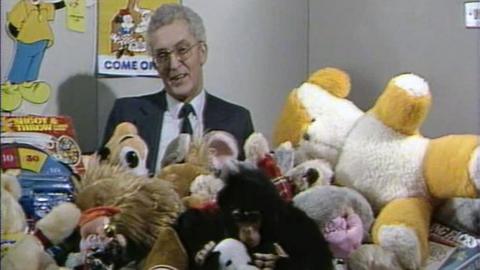 Abbey National director John Bayliss behind a pile of children's toys.