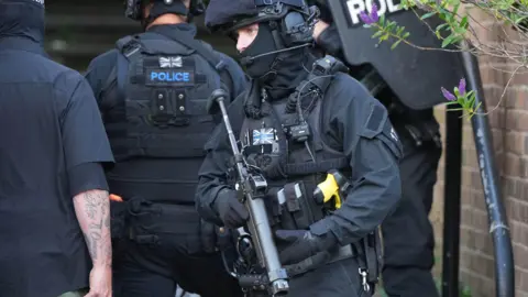 Several armed police officers in full kit at the Whitehawk Road incident.