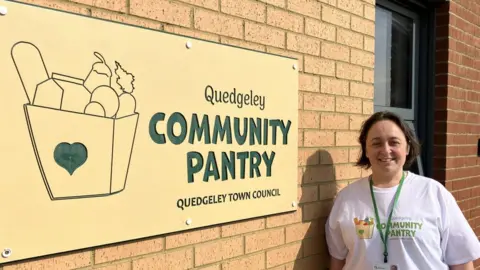 BBC Councillor Vicky Ranford stood by the sign on the front of Quedgeley Community Pantry