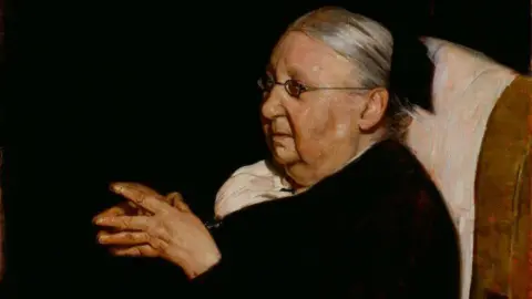 National Portrait Gallery London An oil painting of an elderly woman in black with her hands clasped together. 