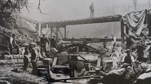 Severn Trent Workers stood below and on a suspended railway line. Pictured in black and white.