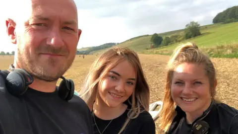 James Jones/PA Media Jason Jones with daughter Ela (middle) and wife Lisa (right)
