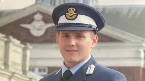 Rob Thomas Flt Lt Rob Thomas in his earlier years in RAF uniform. He's wearing a navy suit. 