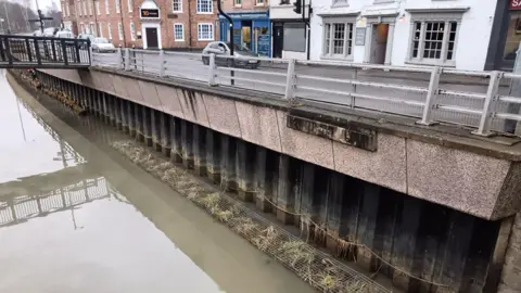 East Mercia Rivers Trust The concrete edge to the river running along side a road now has a line of floating plants along the edge.