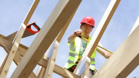 Getty Images A workman on a roof
