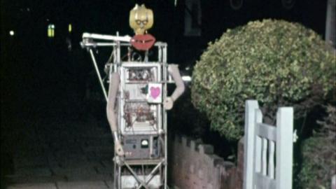 A radio controlled robot with glasses, large red lips and mannequin arms.